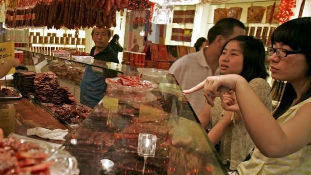 Mujeres chinas comprando carne bovina
